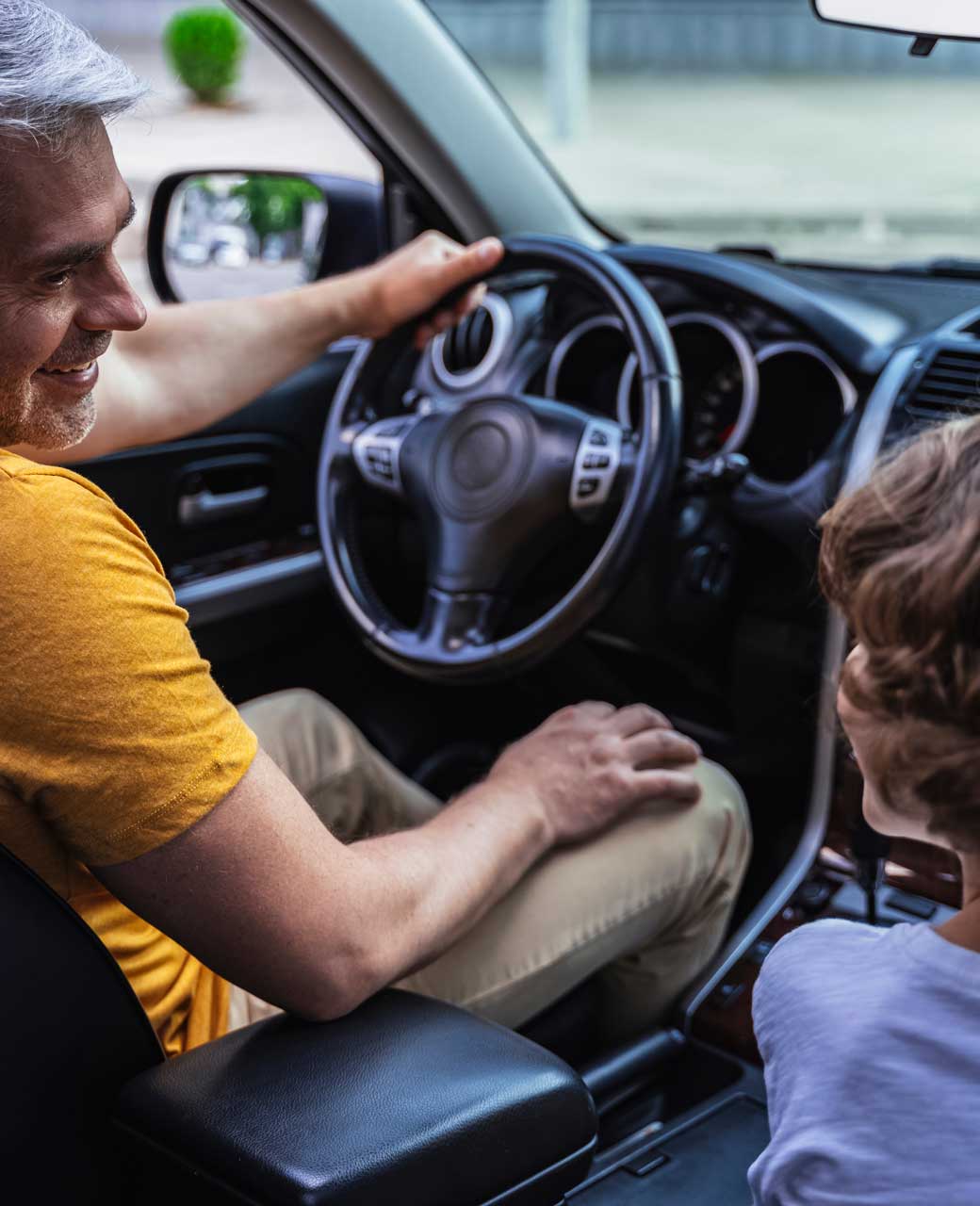 hombre conduciendo un auto junto a un niño