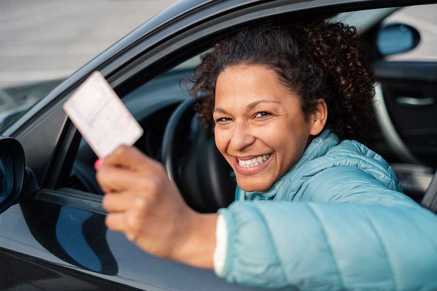 mujer mostrando su licencias de conducir