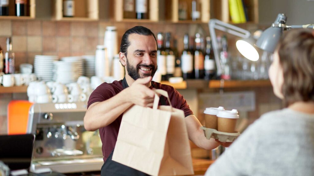 Empleado entregando un pedido en una cafetería