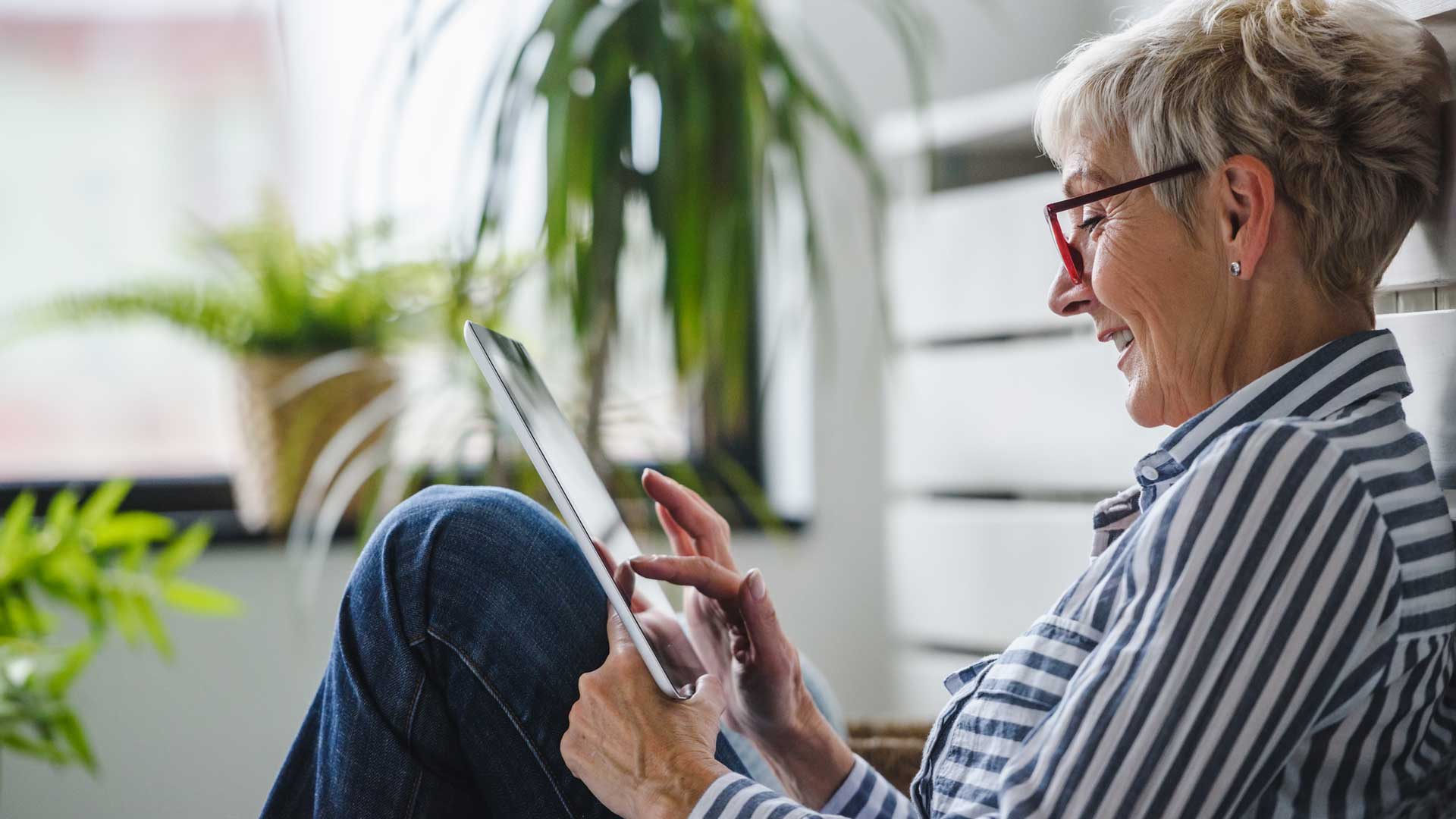 mujer utilizando un dispositivo móvil para descargar la factura de su póliza de seguro