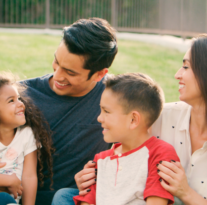 Familia sonriente disfrutando de un momento juntos, representando la protección y tranquilidad que brindan los seguros para personas y familias