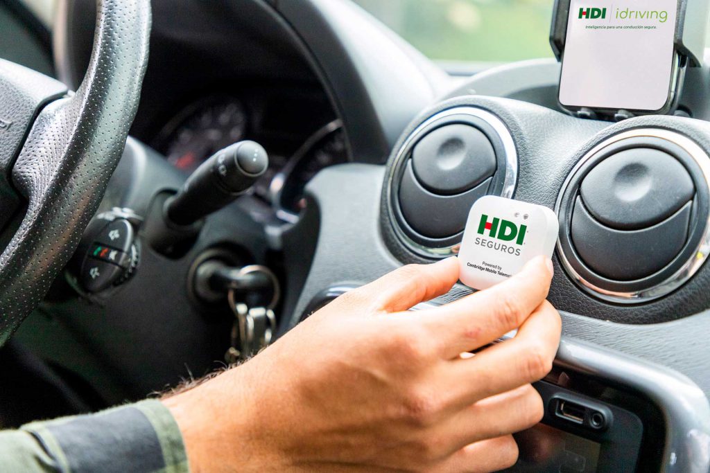 Hombre sosteniendo el dispositivo de Amplia iDriving HDI SEGUROS