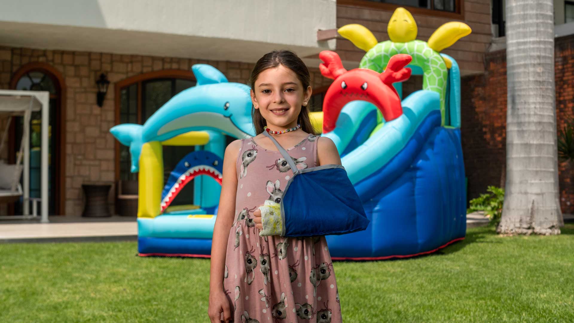 Niña sonriendo con el brazo izquierdo enyesado