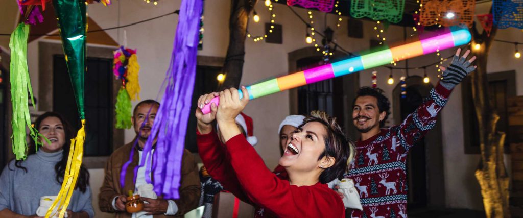 Mujer en una posada pegándole a una piñata