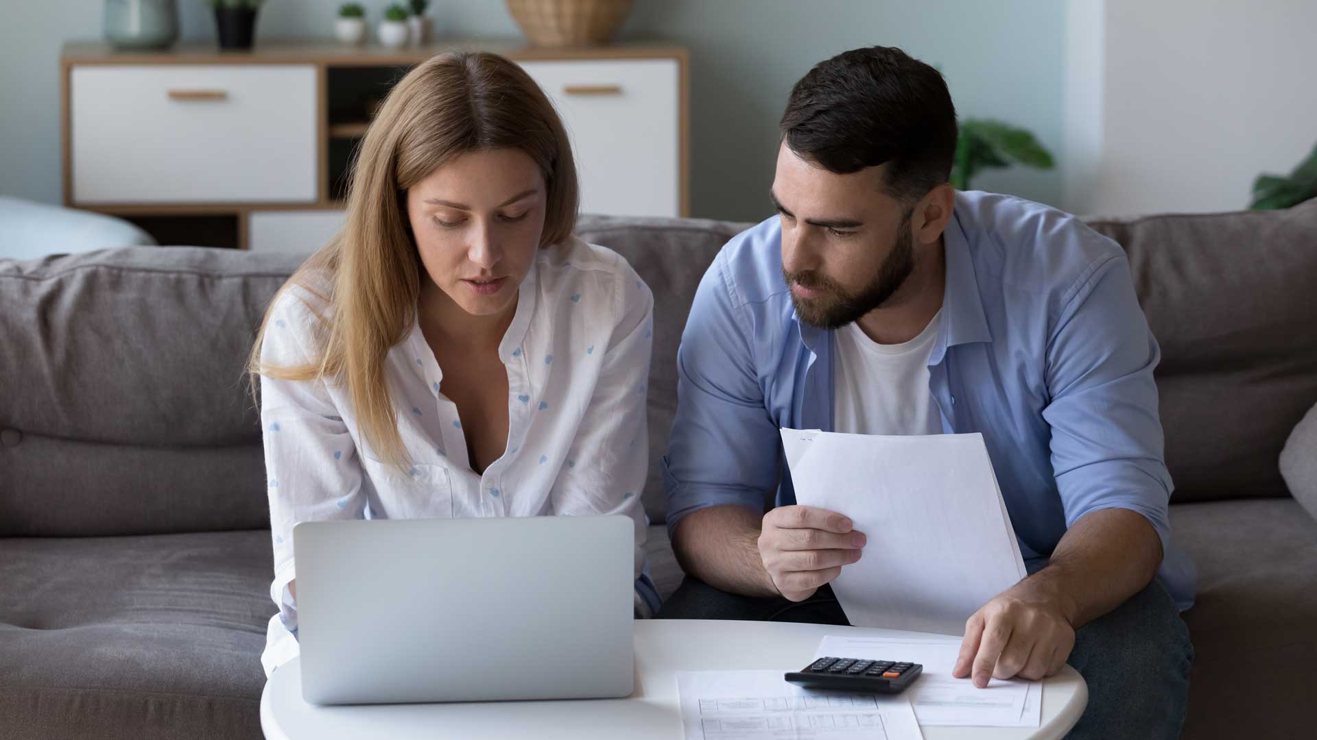 Pareja sentada en un sillón revisando documentación Pareja sentada en un sillón revisando documentación | HDI SEGUROS