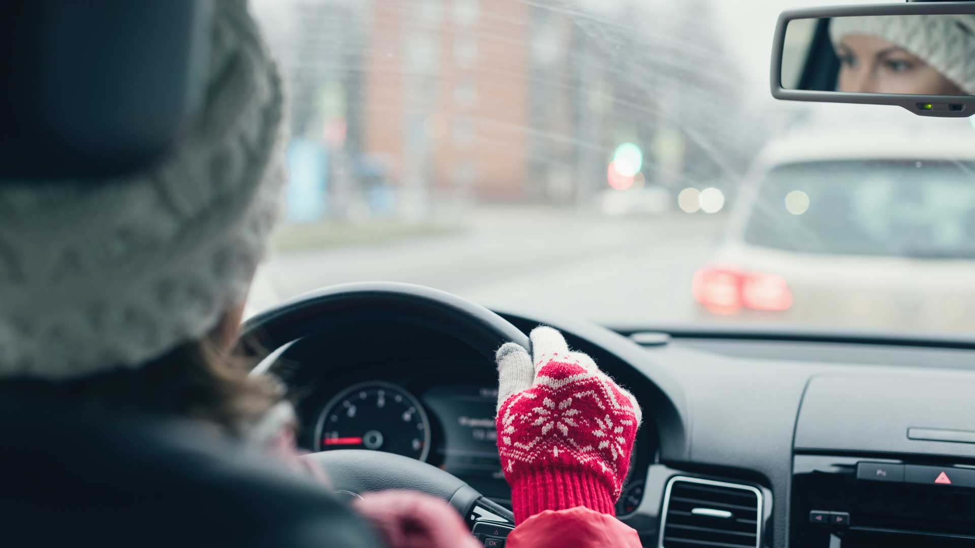 Mujer adulta manejando sobre un paisaje invernal.