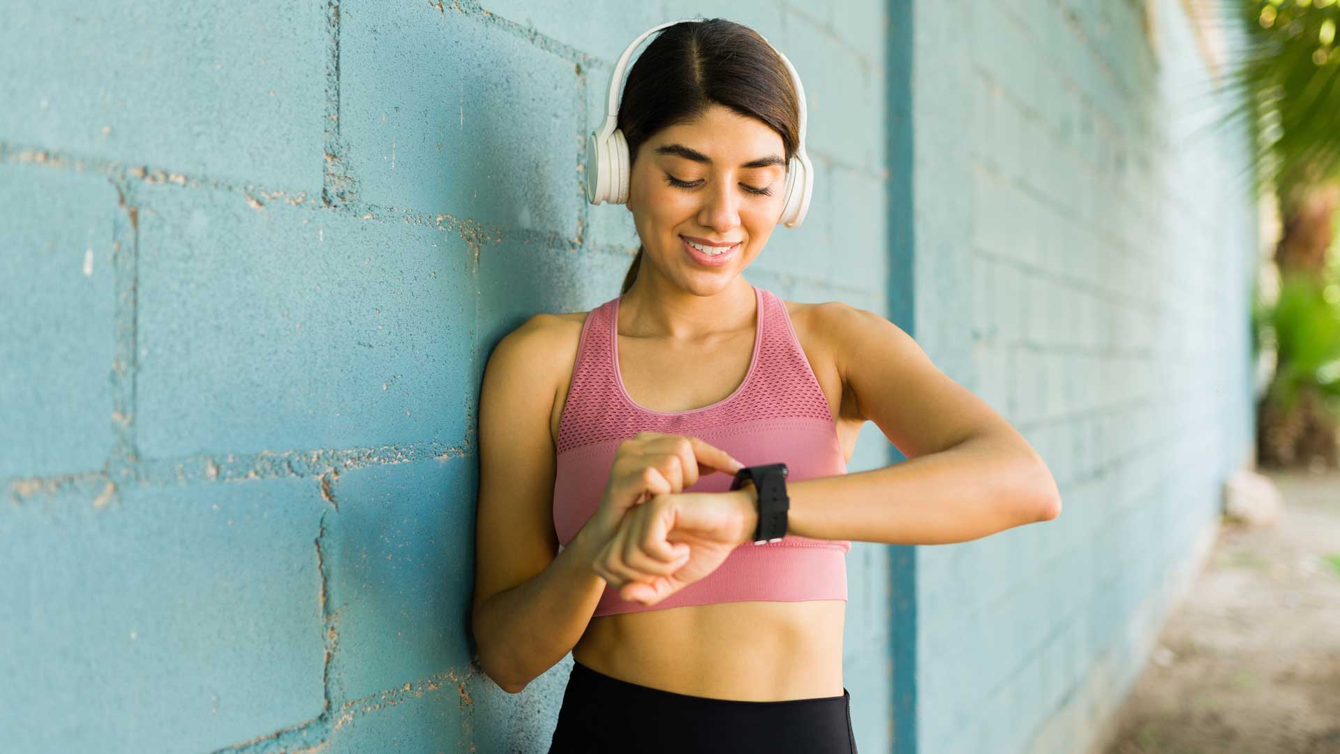 Mujer joven monitoreando sus signos vitales con su reloj inteligente.
