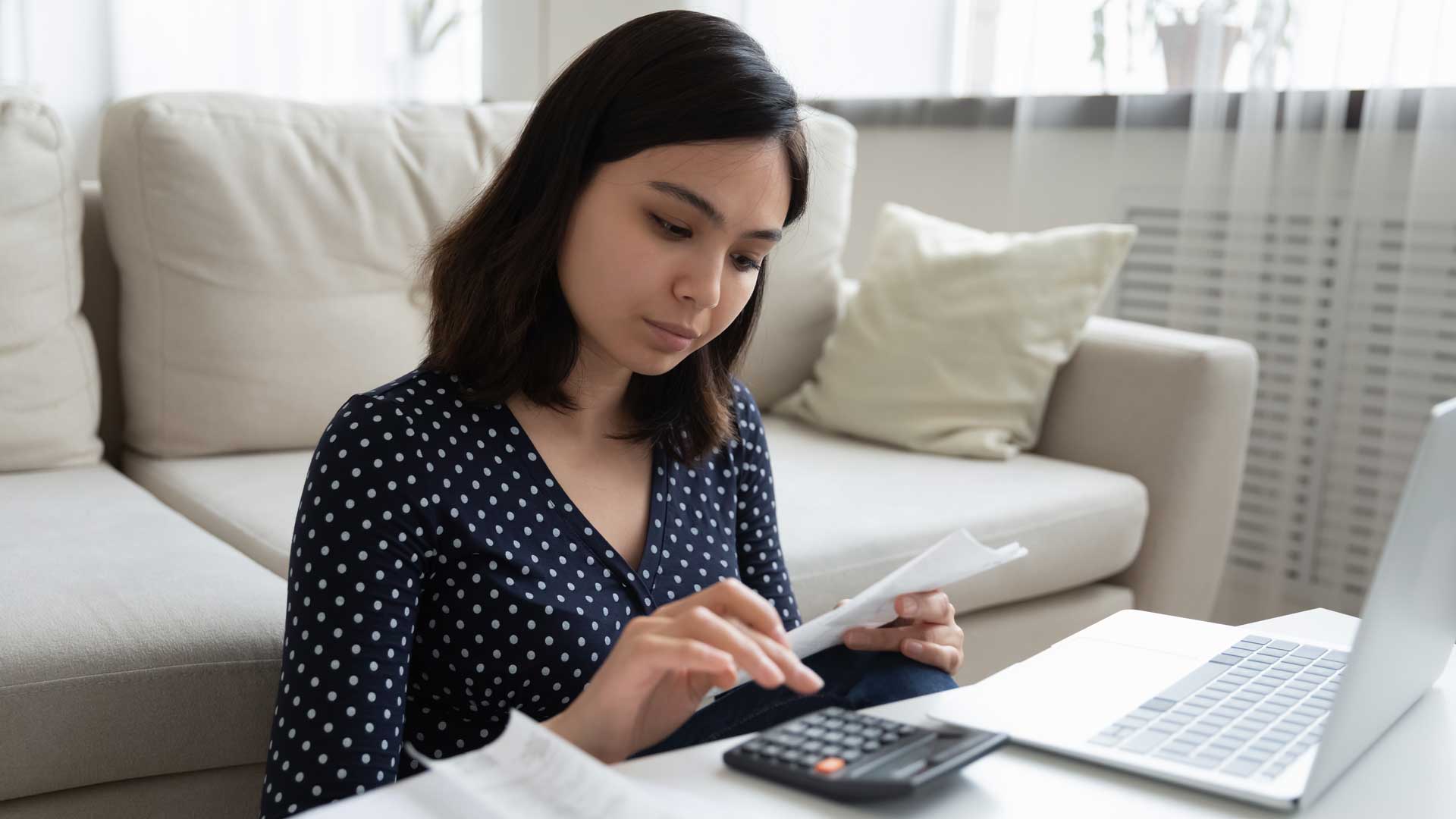 Mujer realizando cálculos para sus pagos.