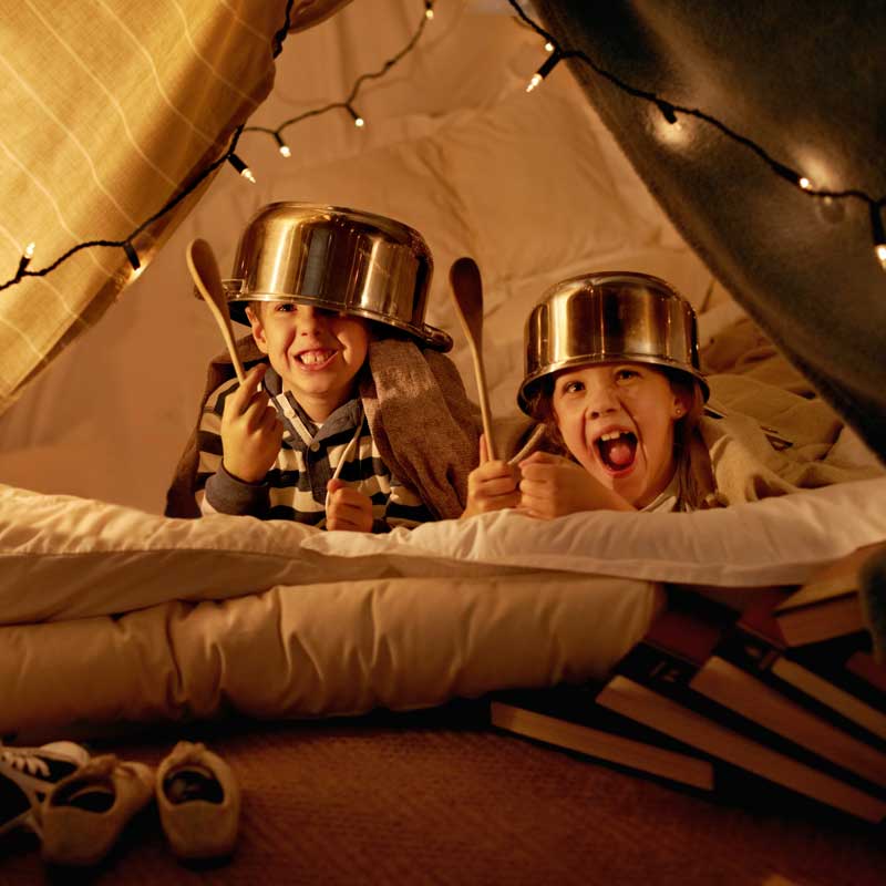 Niños jugando campamento en casa
