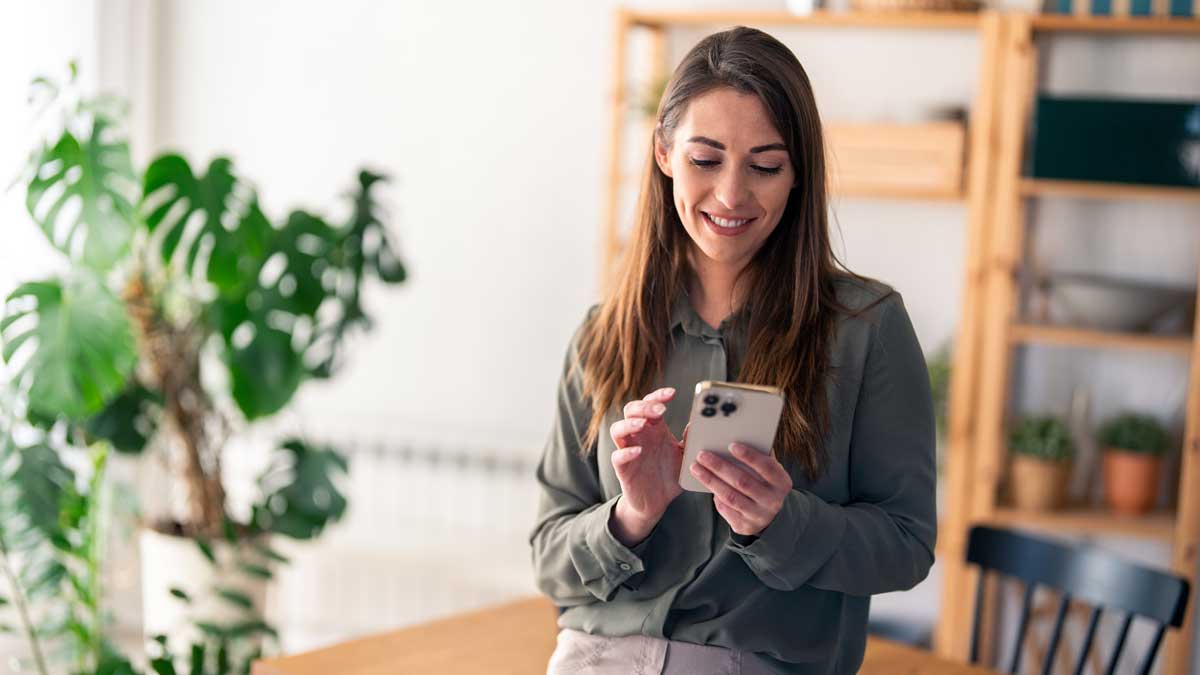 Mujer usando su celular para cotizar un seguro de auto en línea.