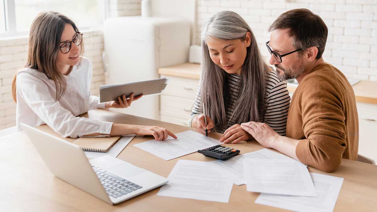 Familia reunida consultando opciones de seguro en una laptop.