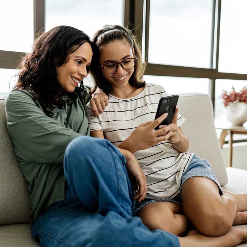 Madre e hija conversando relajados en casa.