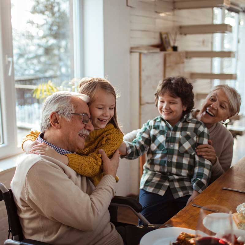Abuelos jugando con nietos dentro de una casa segura.