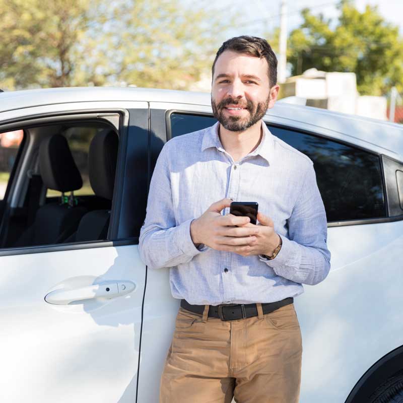 Conductor relajado fuera de su auto inteligente.