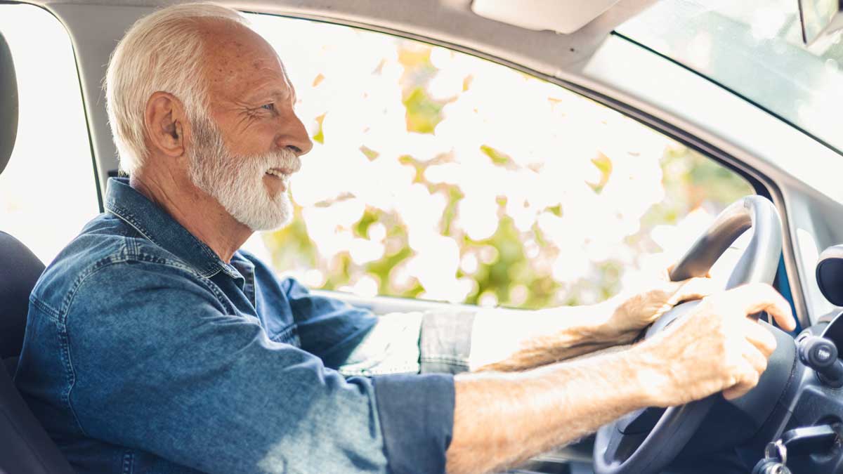 Hombre mayor conduciendo auto con tranquilidad.