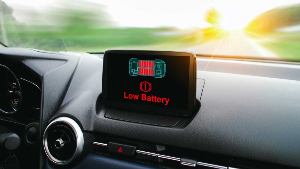Tablero de auto con pantalla indicando batería baja.