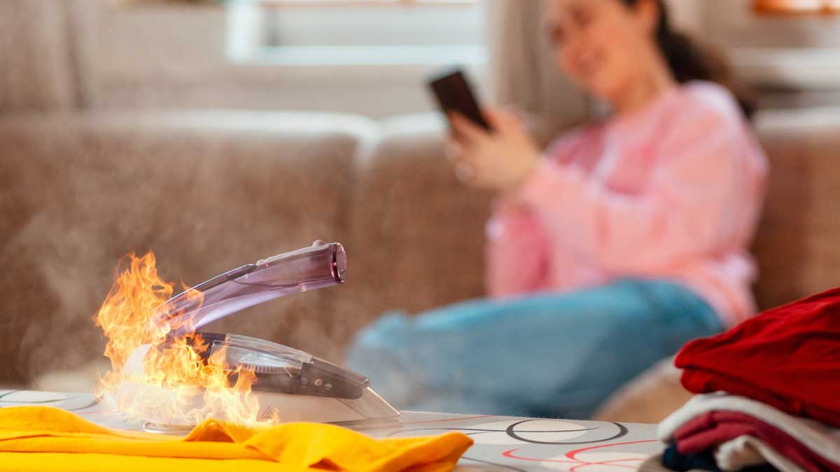 Mujer distraída en su celular no ve fuego saliendo de su plancha.
