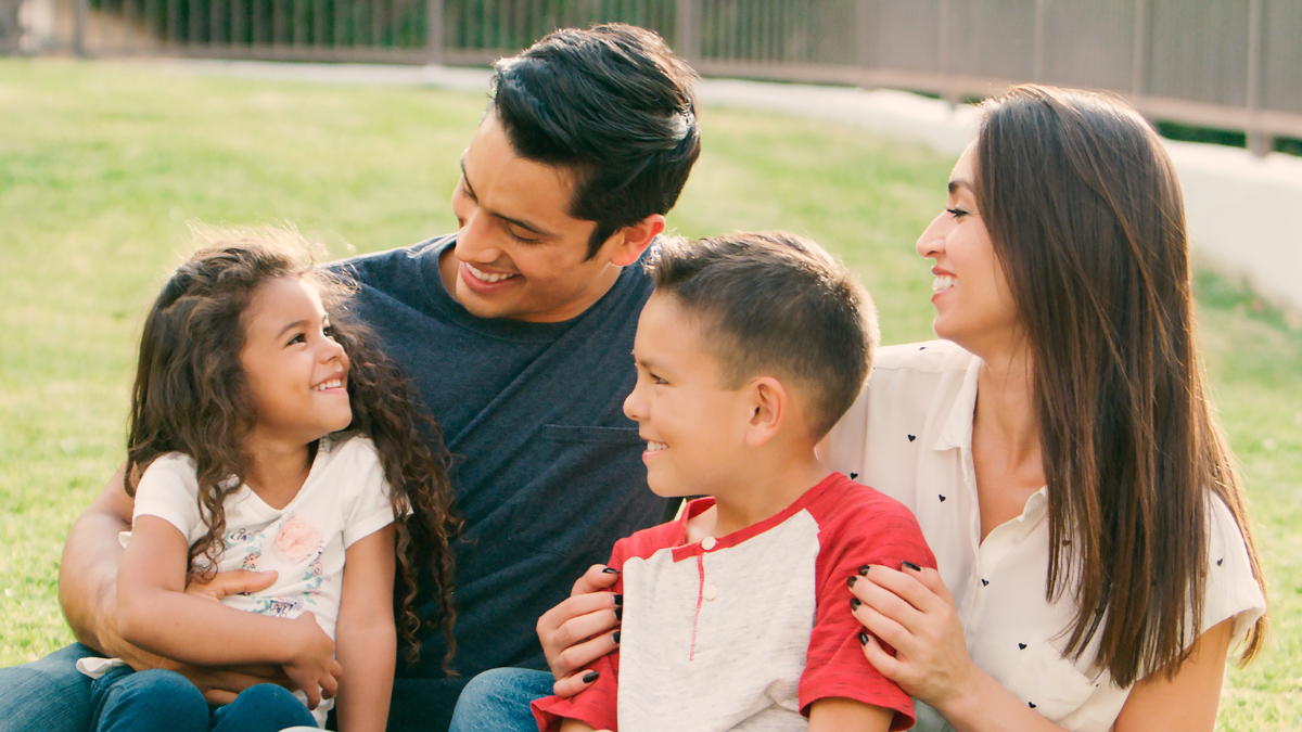 Familia sonriente disfrutando de un momento juntos, representando la protección y tranquilidad que brindan los seguros para personas y familias