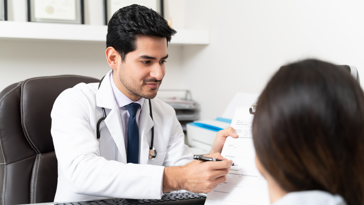 Doctor y paciente en consulta en hospital. Doctor joven atiende a paciente mujer.