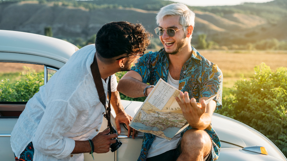 Personas revisando la ruta en un mapa antes de emprender un viaje por carretera de forma segura en automóvil.