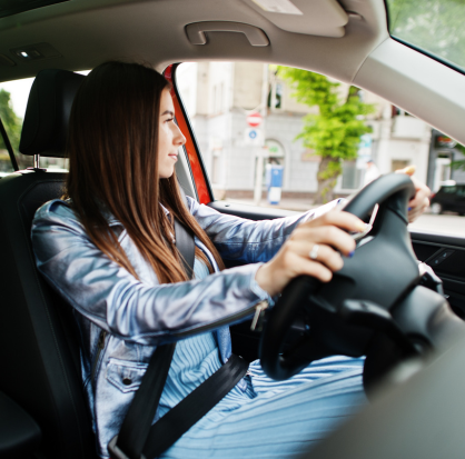 Mujer conduciendo un automóvil mientras usa el cinturón de seguridad