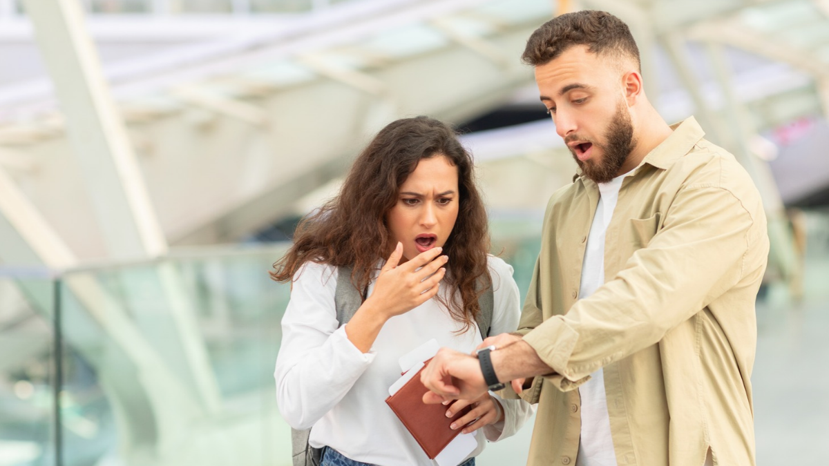 Pareja consulta su teléfono móvil en un centro comercial mientras muestra preocupación.