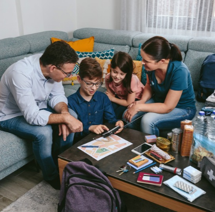 Padres explicando a sus hijos cómo usar los artículos del kit de emergencia