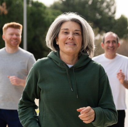 Mujer adulta mayor corriendo en un parque, promoviendo el envejecimiento saludable y la actividad física.