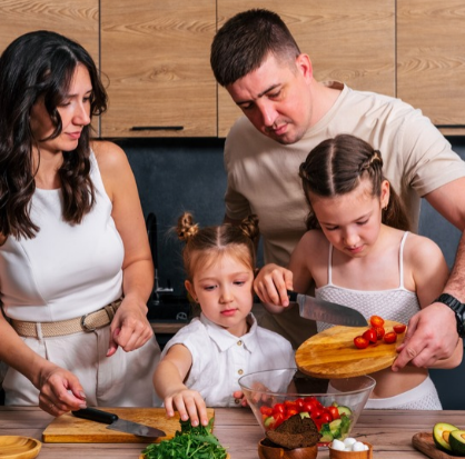 Familia de 4 cocinando platillos saludables en la cocina de su casa